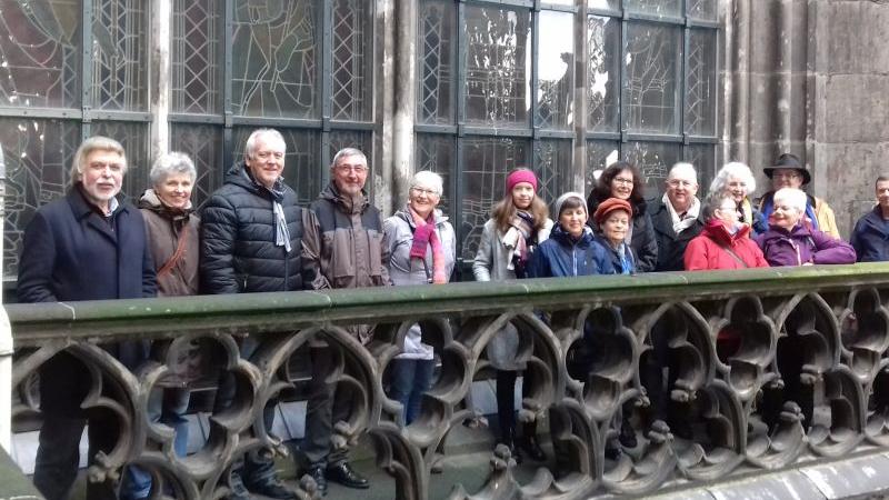 Die Gruppe schaut von der Dachbrüstung in die Kamera.