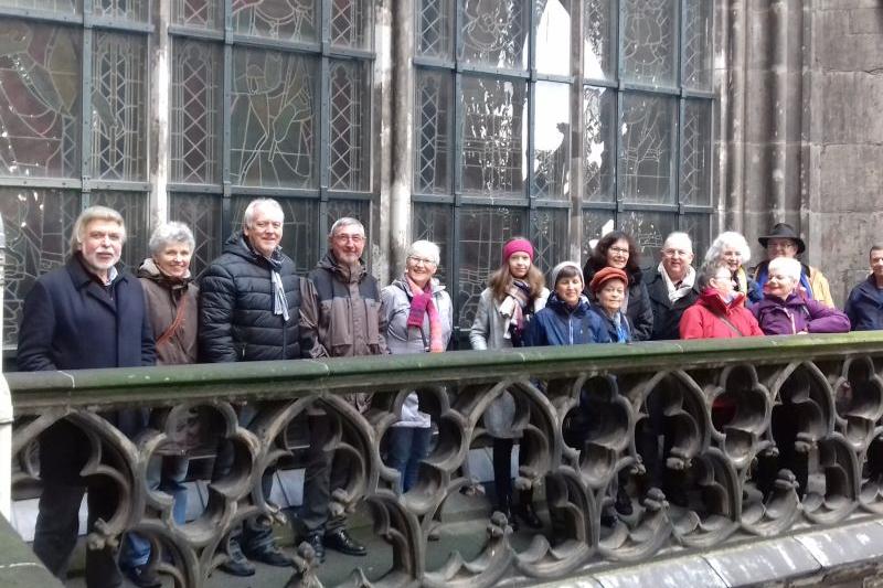 Die Gruppe schaut von der Dachbrüstung in die Kamera.