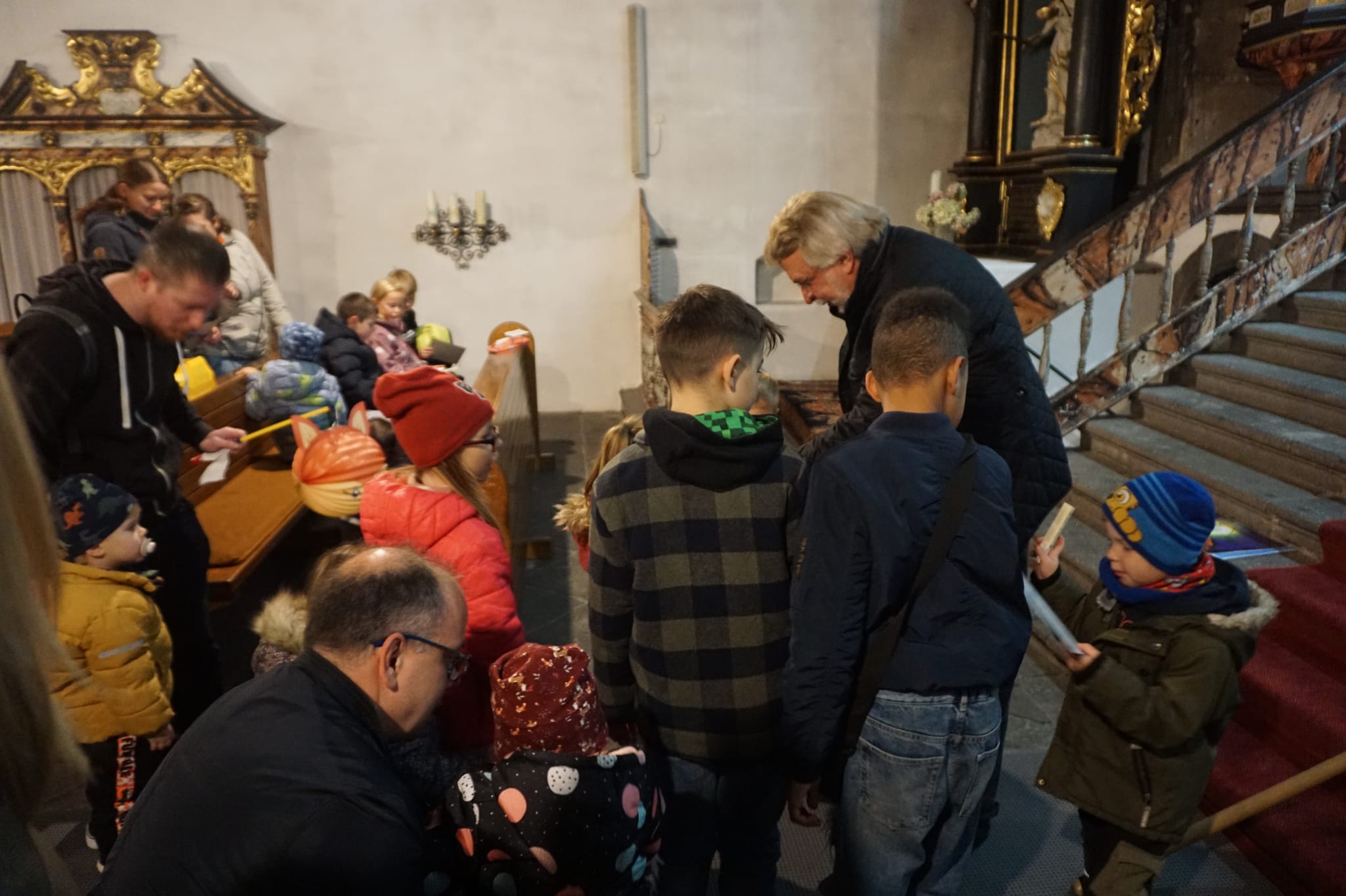 Kinder holen sich Schokolade und ein Ausmalbild ab.