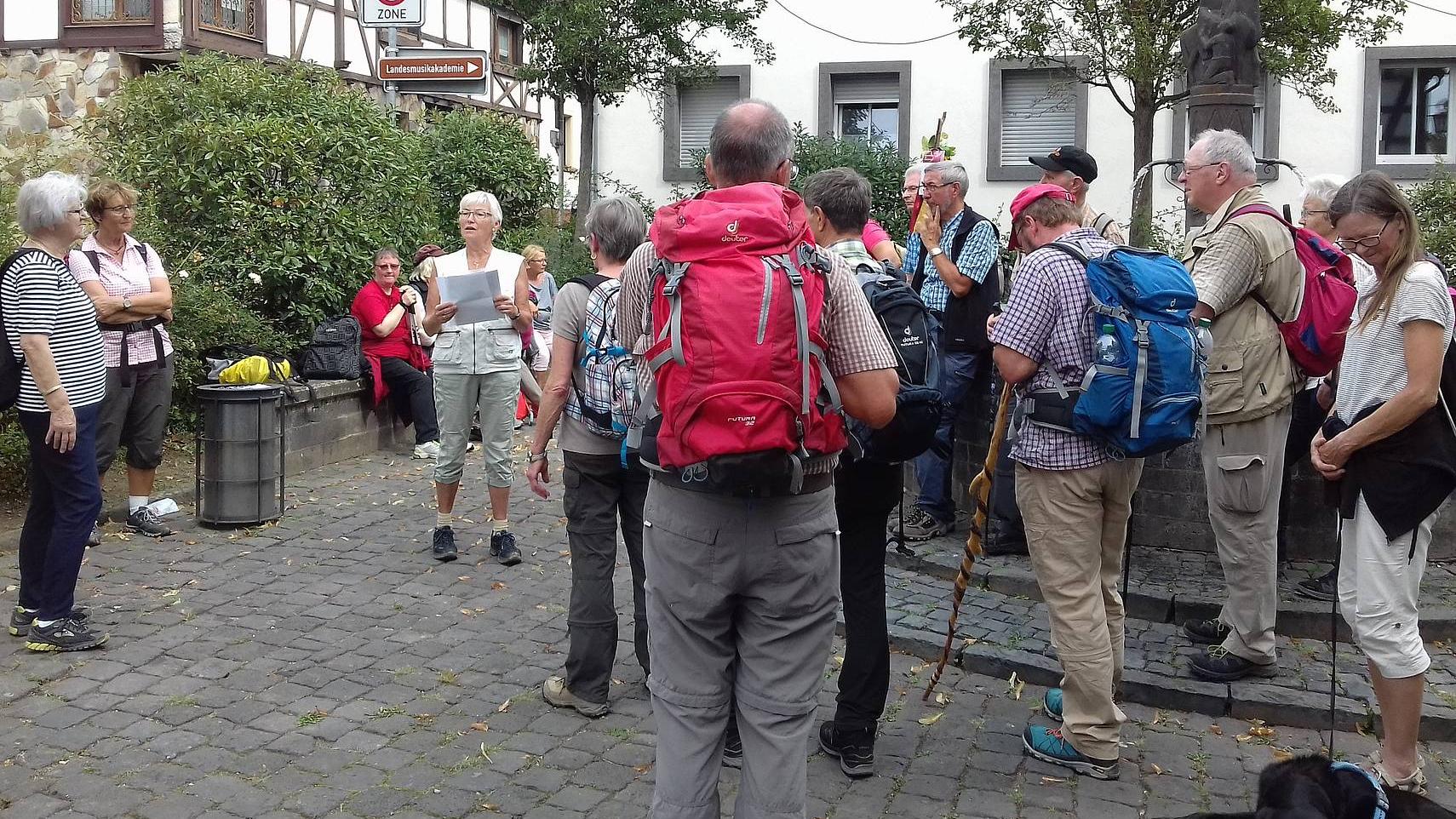 Ingrid Hillen liest für die versammelte Gruppe einen Impuls am Martinsbrunnen in Engers.